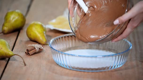 Θηλυκό σεφ χέρια έκχυση χυλό σε ταψί. Κάνοντας σοκολάτα πίτα με αχλάδια. — Αρχείο Βίντεο