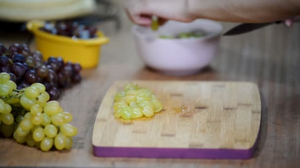 Chef-kok gesneden druiven op een snijplank koks handen — Stockvideo