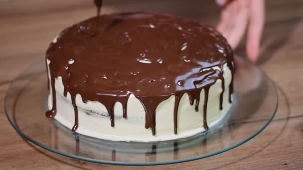 Mujer vierte chocolate derretido en un pastel de chocolate . — Vídeo de stock
