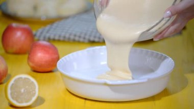 Kadın şef yemek pişirme içine dökme meyilli eller. Elmalı turta Charlotte pişirme aşaması.