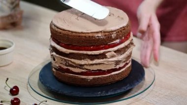 Tanınmayan kadın pasta yemek iştah açıcı katman kek mutfak üzerine sıkma krem çikolata.