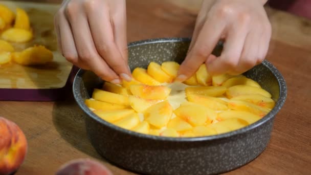 Процесс приготовления персикового пирога. Женщина положила свежий персик на тесто . — стоковое видео