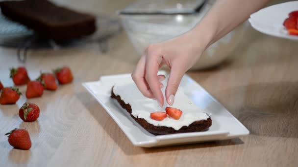 A kezét a nő cukrász teszi egy finom eper torta. A konyhában főzés desszert. — Stock videók