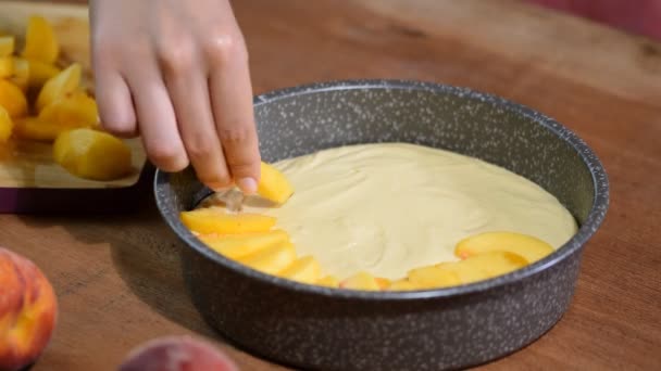 El proceso de hacer un pastel de durazno. Mujer mano poner melocotón fresco en la masa . — Vídeos de Stock