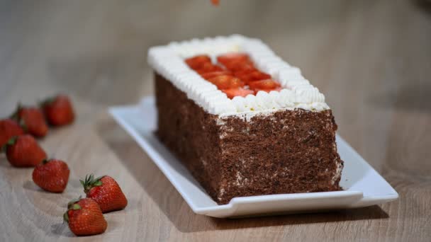 Woman decorating delicious chocolate cake with strawberries on table. — Stock Video