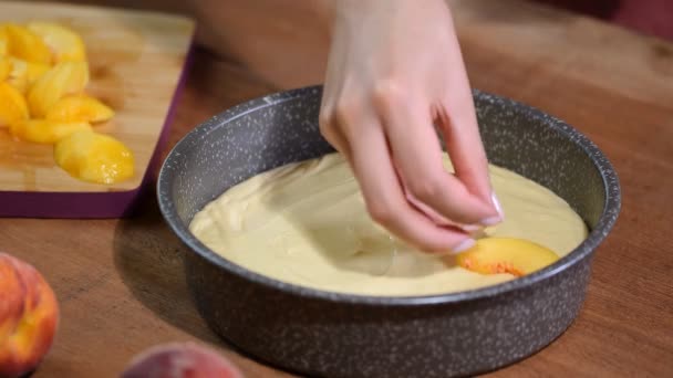 Proses membuat pie persik. Tangan wanita menaruh persik segar di adonan . — Stok Video