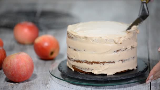 Chef décorant un délicieux gâteau avec de la crème. Faire gâteau aux pommes au caramel . — Video