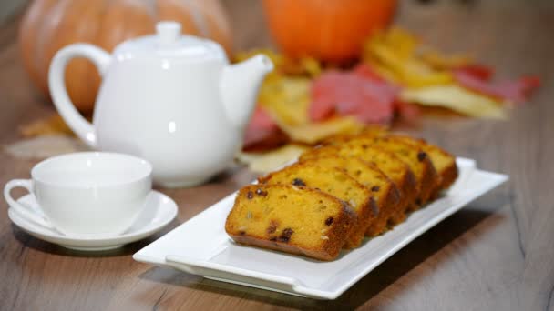 Inserisca il piatto ha tagliato il dolce pane di zucca. Versare il tè in tazza . — Video Stock