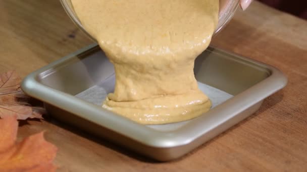 Женщина наливает тесто в плесень, чтобы сделать тыквенный торт дома — стоковое видео