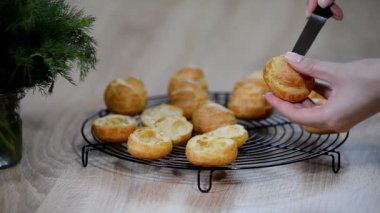 Ev yapımı profiterol bir bıçak ile kesmek.