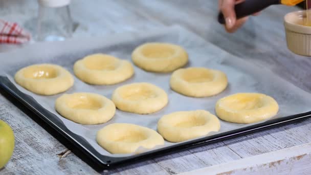 Beredning av en hemmagjord öppen bullar Vatrushka, färska bakverk, smörjfetter bullarna med ett ägg. — Stockvideo