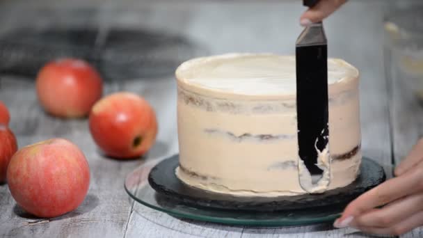 Chef dekoriert einen leckeren Kuchen mit Sahne. Herstellung von Karamell-Apfelkuchen. — Stockvideo