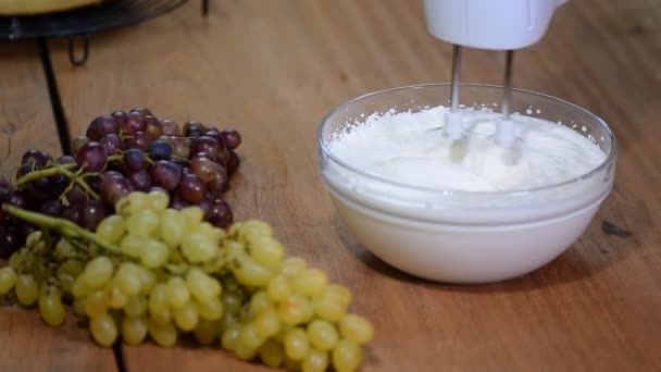 Crema batida en cuenco de cristal con batidores . — Vídeo de stock