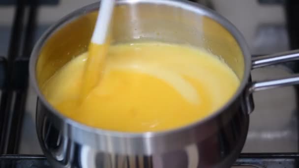 Koken van Oranje gestremde melk in een pan. — Stockvideo