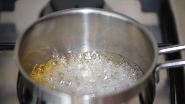 Sciroppo di caramello bollente sul fuoco in pentola. Miscela di zucchero bollente. Fare sciroppo d'oro — Video Stock