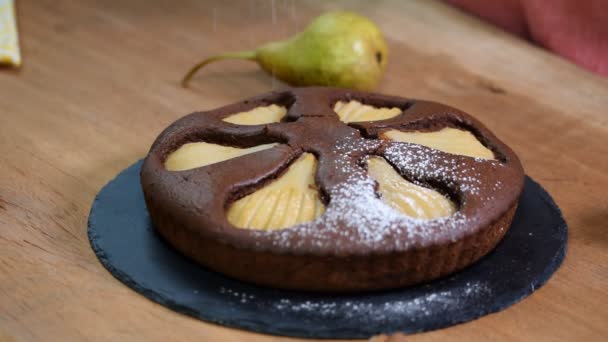 Zelfgemaakte chocolade cake met peren. Strooi een poeder suiker. — Stockvideo