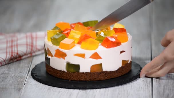 Разрезание торта с красочными фруктовыми кусочками желе . — стоковое видео