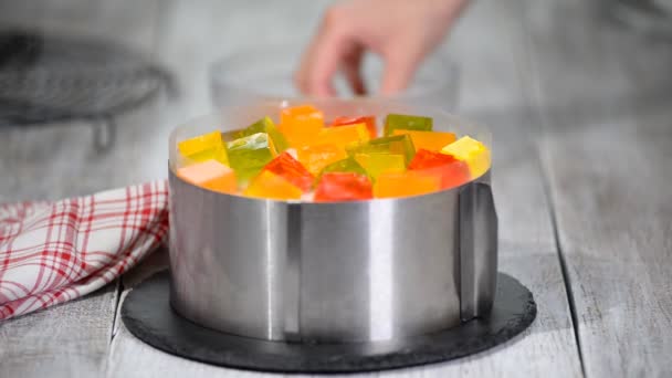 Изготовление торта из цветных фруктовых кусочков желе . — стоковое видео