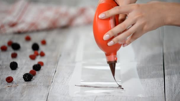Cukrář v kuchyni připravuje čokoládová dekorace na pracovní desku. — Stock video
