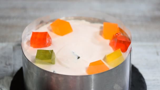 Виготовлення торта з барвистими фруктовими шматочками желе . — стокове відео