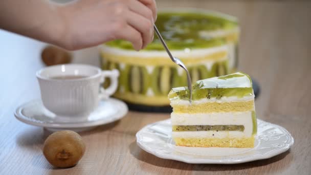 Eten de stuk taart voor de mousse van de eigengemaakte kiwi. — Stockvideo