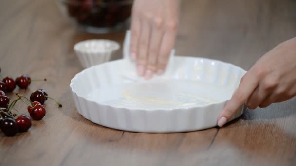 Kuchen backen. Vorbereitung der Backform. Weibliche Hände fetten mit Fett die Backform ein. — Stockvideo