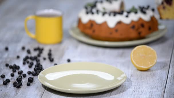 맛 있는 디저트 검은 건포도, 검은 건포도와 소박한 스타일의 테이블에 레몬 유약 달콤한 맛 있는 휴가 케이크. — 비디오