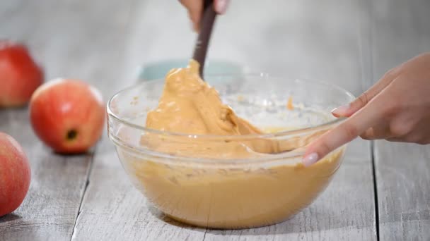 Un chef en la cocina se mezcla en un recipiente de vidrio con espátula. Hacer pastel de manzanas de caramelo . — Vídeo de stock