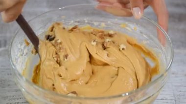 Mutfakta bir aşçı bir cam kapta spatula ile karışımları. Karamelli elma kek yapmak.