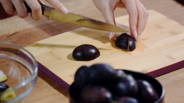 Frau kocht und schneidet Pflaume auf Holzschneidebrett. Gesundes Essen zubereiten. — Stockvideo