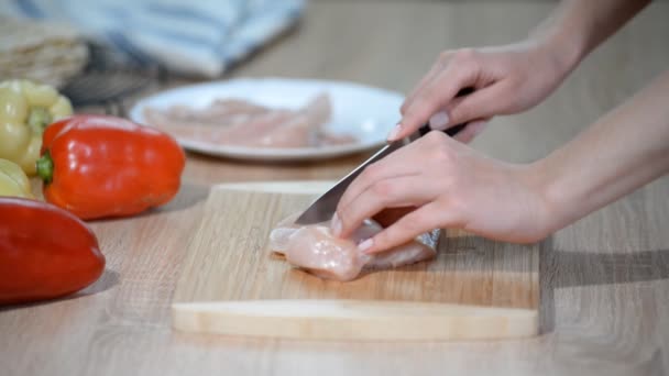 Donna taglio petto di pollo sul tavolo . — Video Stock