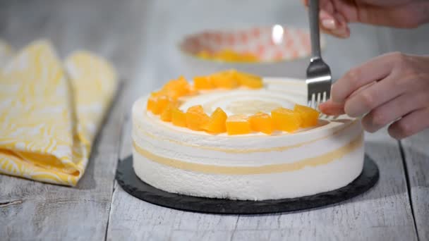 Versieren mousse cake met stukjes perziken. — Stockvideo