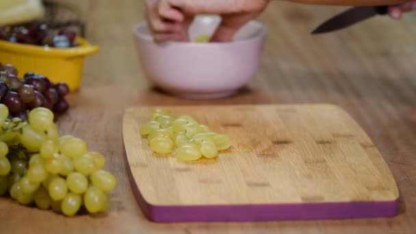 Chef-kok gesneden druiven op een snijplank koks handen. Close-up — Stockvideo