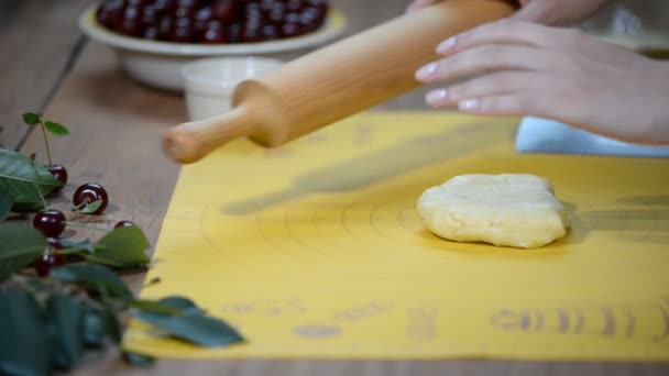 Mani femminili rotolare l'impasto. Donna che fa torta di ciliegie . — Video Stock