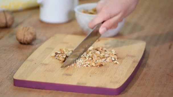 Kvinnliga kockar händerna hugga valnötter på trä skärbräda. — Stockvideo