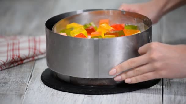 Изготовление торта из цветных фруктовых кусочков желе . — стоковое видео