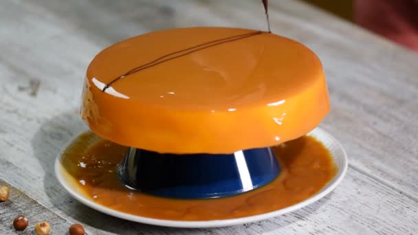 Proces van het creëren van heerlijke taart. Onherkenbaar banketbakkers handen versieren karamel geglazuurde taart met chocolade. — Stockvideo