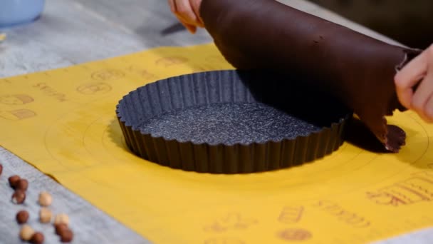 Cooking chocolate tart. The cook is laying out the dough in the baking mold. — Stock Video