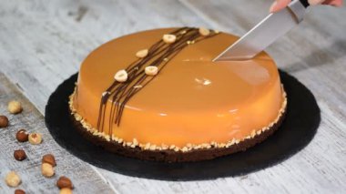 Karamelli mus kek kesme el. Karamel pasta, mus tatlı bir plaka üzerinde.