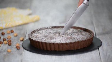 Rustik arka plan üzerinde kesme ev yapımı koyu çikolata tart.