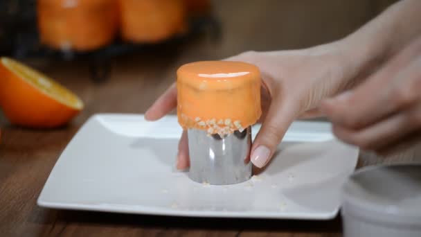 Close up confectioner decorate small mirror glaze cake with a nuts at kitchen. — Stockvideo