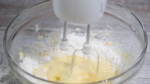 Beating butter with powdered sugar. Making of a cream for home-made cakes with a mixer — Stock Video