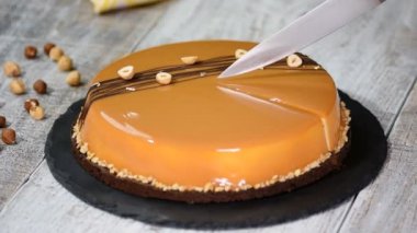 Karamelli mus kek kesme el. Karamel pasta, mus tatlı bir plaka üzerinde