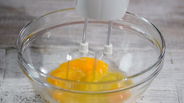 Geslagen eieren met Mixer kunt in kom. Suiker wordt gieten in de kom. — Stockvideo