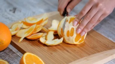 Ahşap kesme tahtası üzerinde soyulmuş portakal.