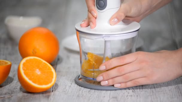L'arancia viene schiacciata in un frullatore . — Video Stock