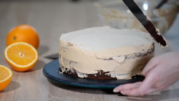 Confeiteiro coloca creme no topo do bolo. Bolo de alisamento Baker com creme de gelo — Vídeo de Stock