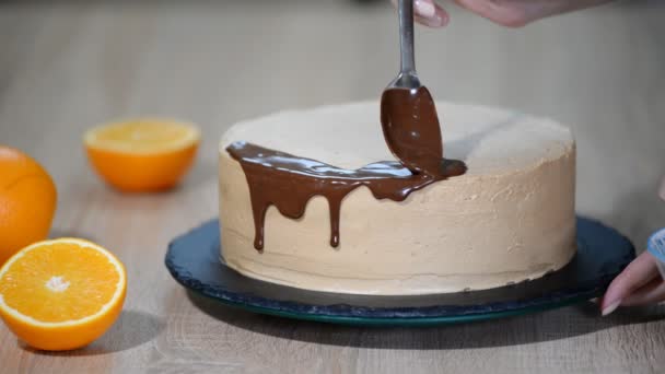 Čokoládová poleva na dortu. Moderní dort. Cukrář zdobí dort.