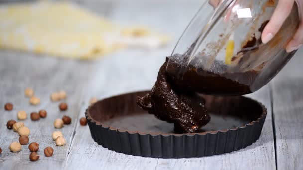 上にチョコレート生地を注ぐ チョコレートのタルトを作る — ストック動画