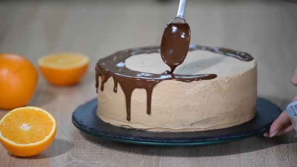 Koch drückt Sahne. Schokolade als Sahnehäubchen. weißer Kuchen mit Schokolade und Sahne bedeckt. Schokoladenkuchen-Dekoration.